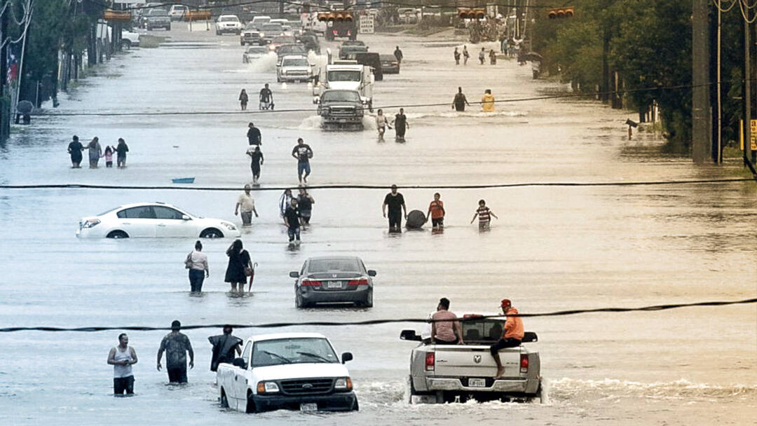 休斯顿街道被洪水淹没，人们站在汽车中间。