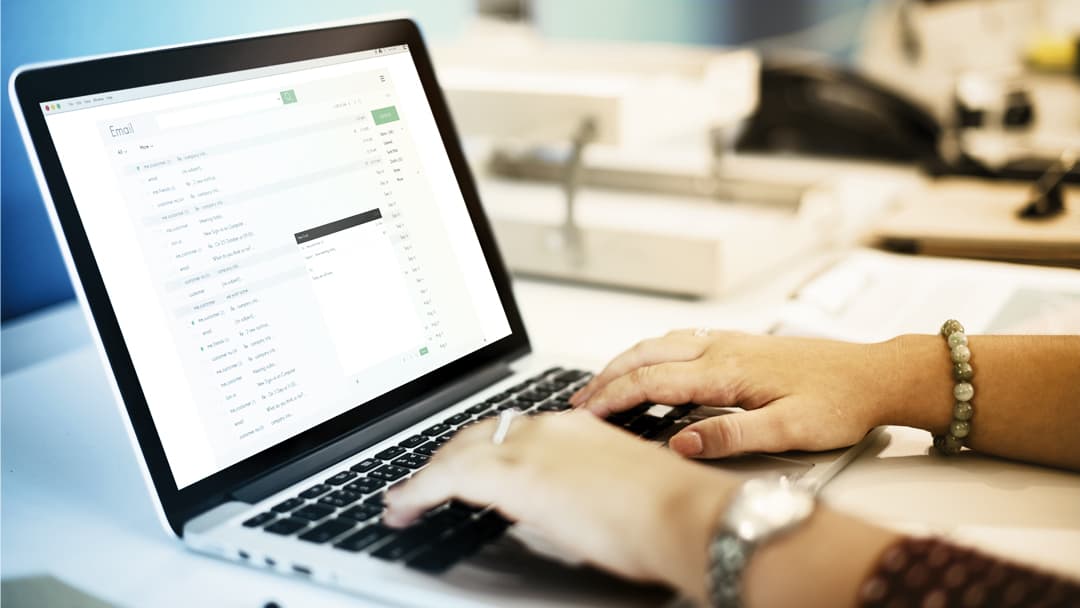 An office worker reviews their email on a laptop computer.