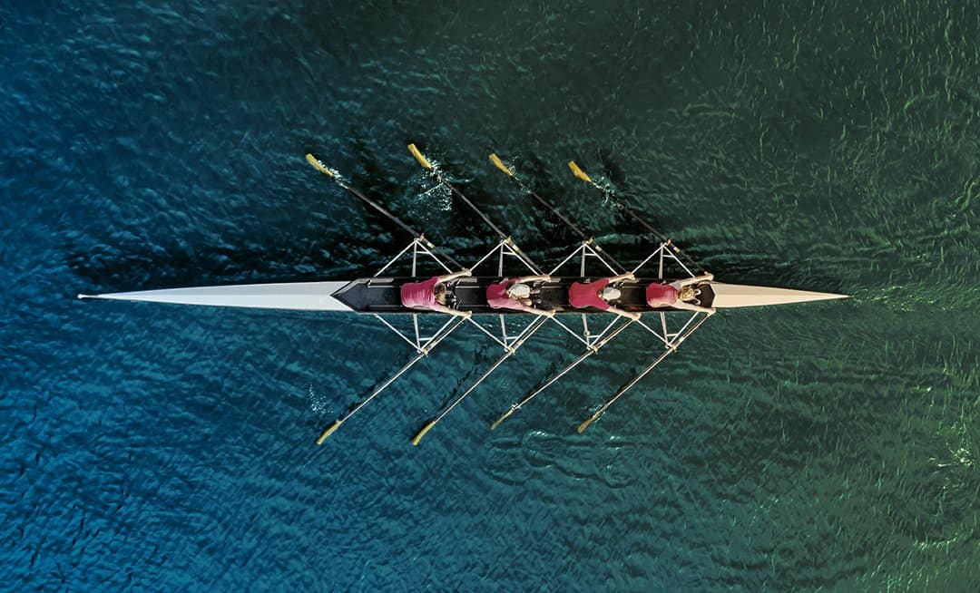女子赛艇队在蓝水上的俯视图。